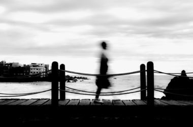 long exposure person walking footbridge by sea against sky